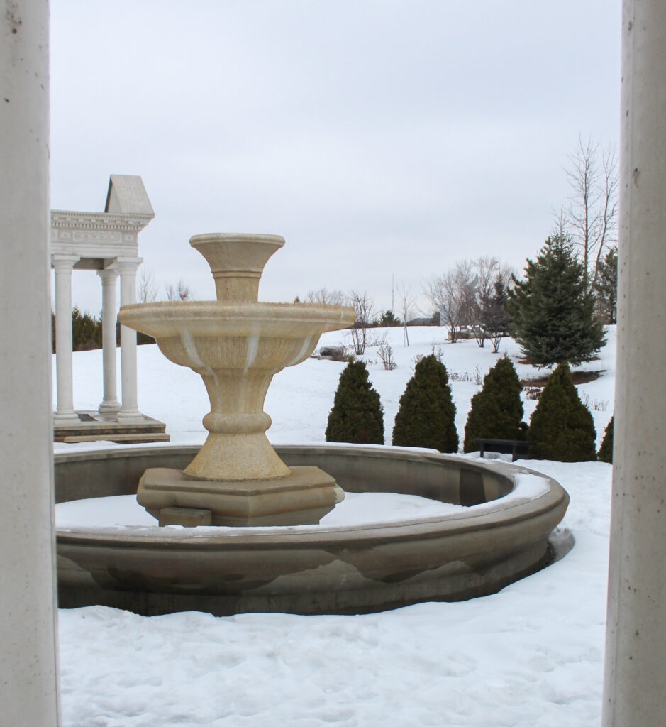 A fountain without the water, covered in snow.