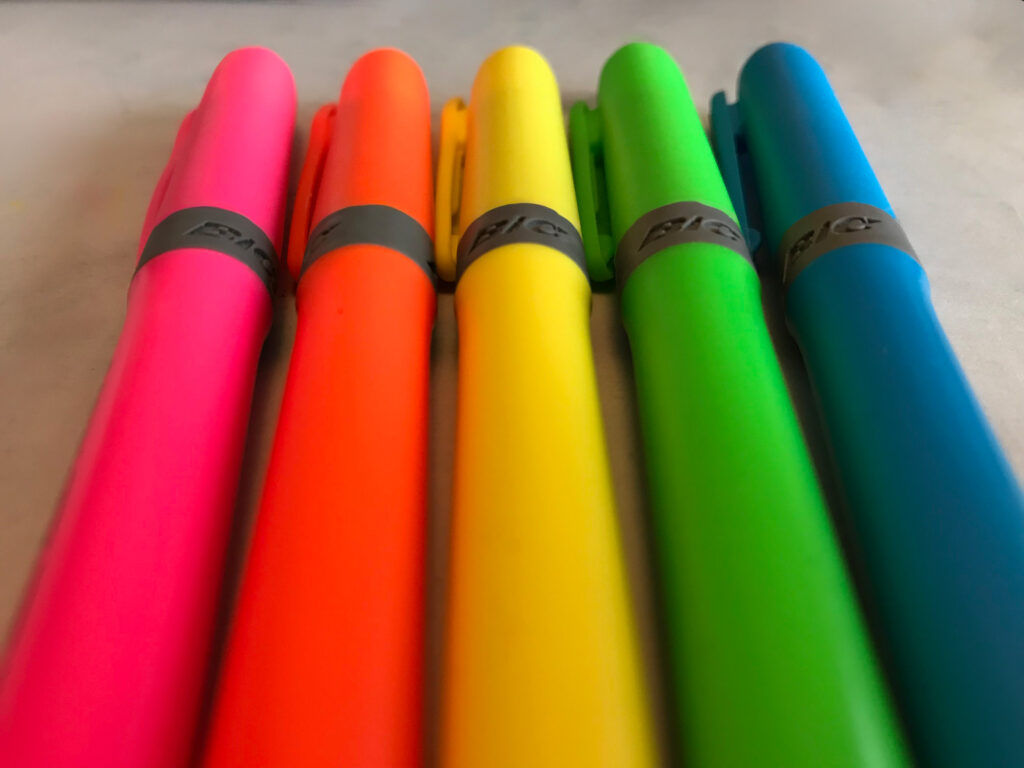 Close-up of five highlighters lined up on a table.